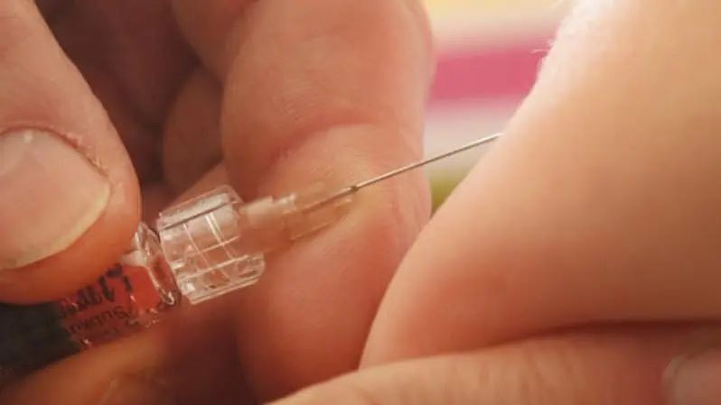 A doctor injects a vaccine against measles, rubella, mumps and chicken pox to an infant. 