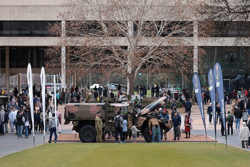 A combat vehicle is on display on the ADFA campus lawn, with parents and prospective students inspecting.