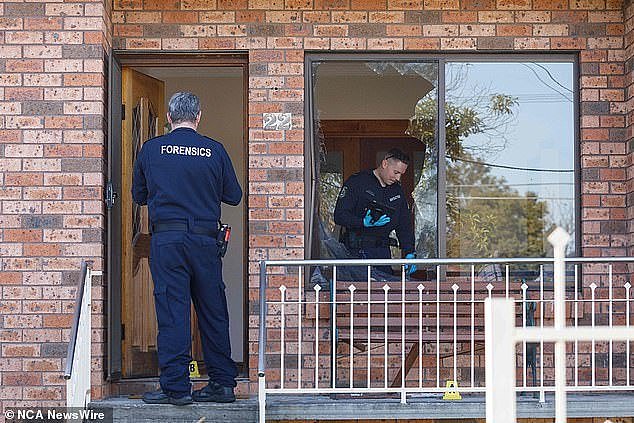 Police say the violence began when the man fired several shots into a home on Antwerp Street in Auburn just before 10pm on Tuesday (pictured, a shattered window at the home)