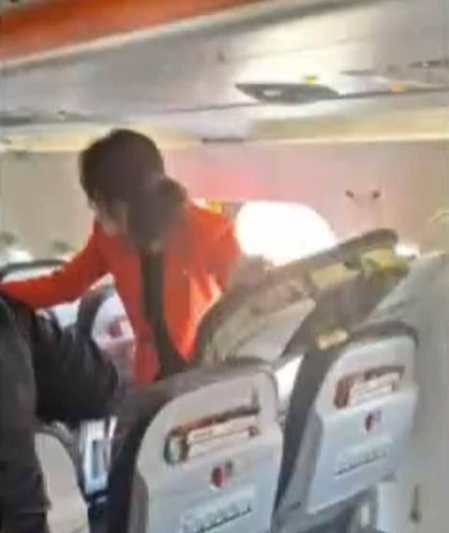 A Jetstar flight attendant is pictured next to the emergency exit after a passenger jumped out