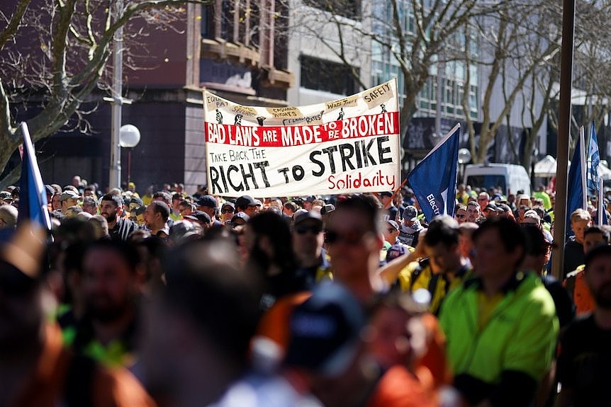 Group of protesters with one holding a sign 'right to strike'.