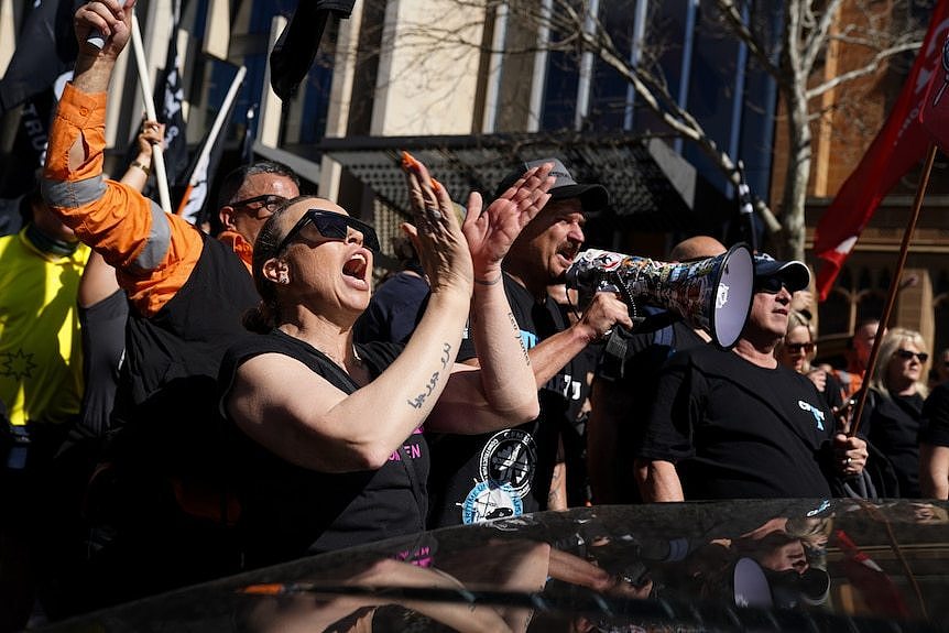 Protesters shouting and speaking into megaphone at a CFMEU rally in Sydney's CBD