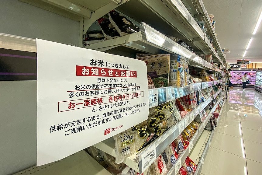 A sign in Japanese on a supermarket shelf.