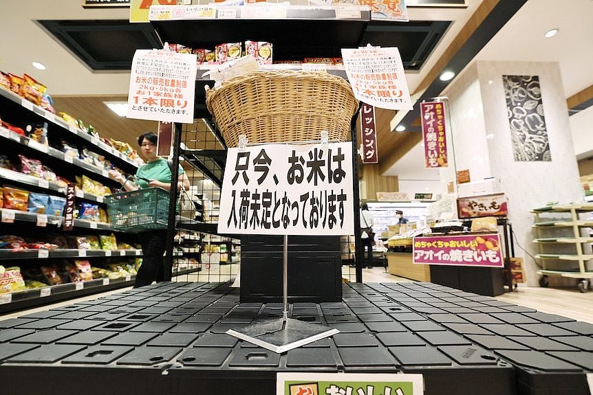 A sign in Japanese on a supermarket display platform. 