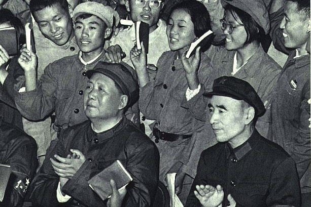 A portrait black and white image shows a crowd of young people in similar military-style suits.