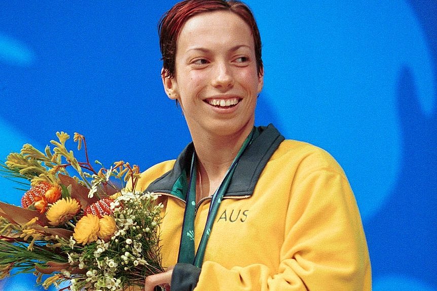 Elizabeth Wright smiles gholding flowers and a silver medal