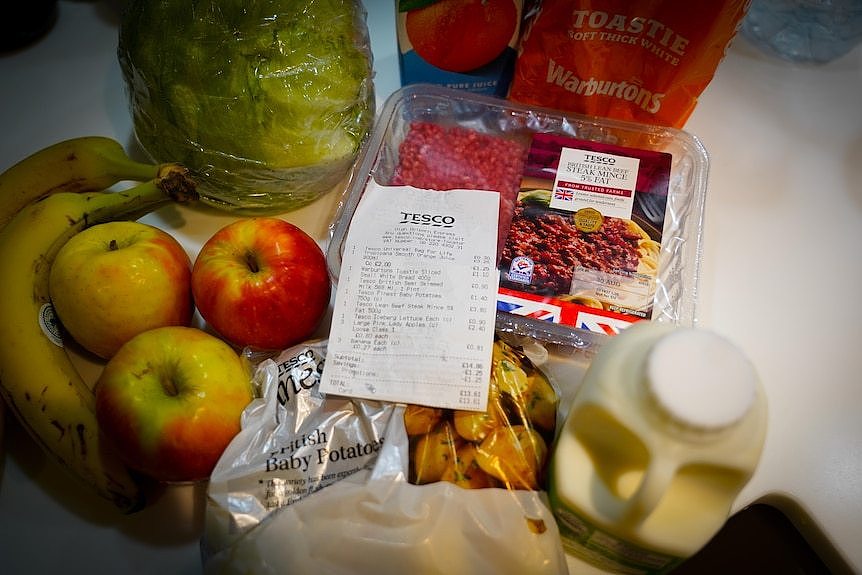 A collection of groceries inlcuding apples. bananas, milk and mince