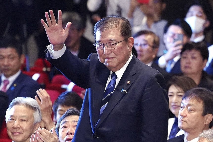 A man standing in a crowd and waves