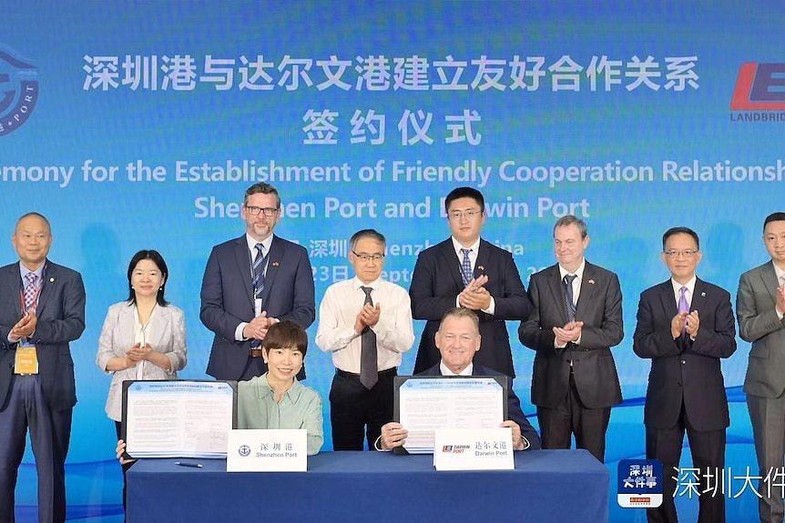 A group of Australian and Chinese in suits pose for a photo.