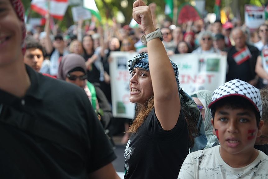 A protester with a raised arm amid the rally in Sydney.