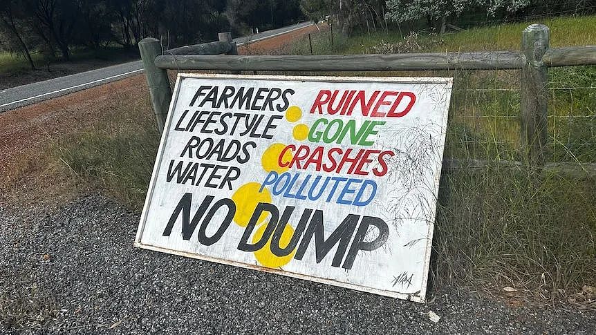 Sign reads Farmers Ruined Lifestyle Gone Roads Crashes Water Polluted No Dump on a paddock fence