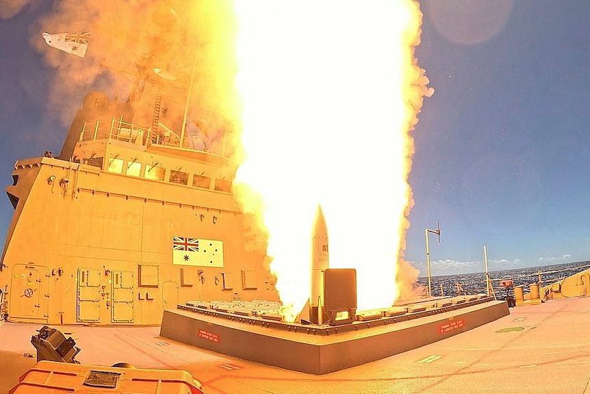 Flames surround the firing of a missile from a military ship