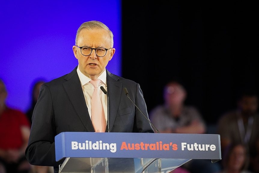 Albanese speaks at a lectern marked 