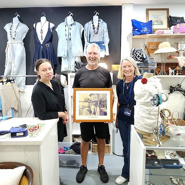 Rob Klaric with Lifeline Mosman staff after finding two framed photos of him and his wife on a European holiday from 30 years ago in the store