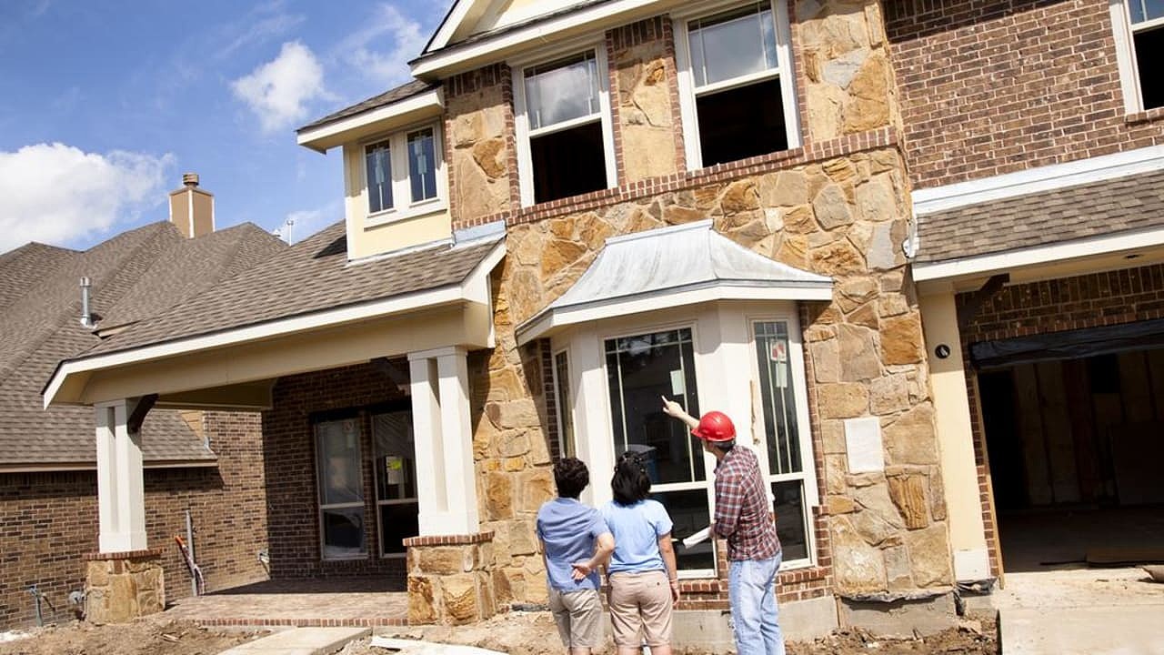 Builder meeting with woman and daughter at new home construction