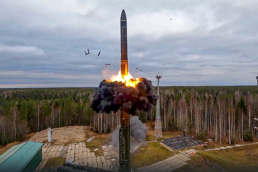 A large ballistic missile taking off from a launch site in the middle of a Russian forest.