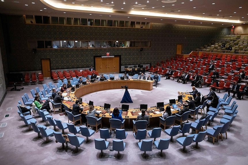 A wide shot of the UN Security council meeting in a circle at its headquarters.