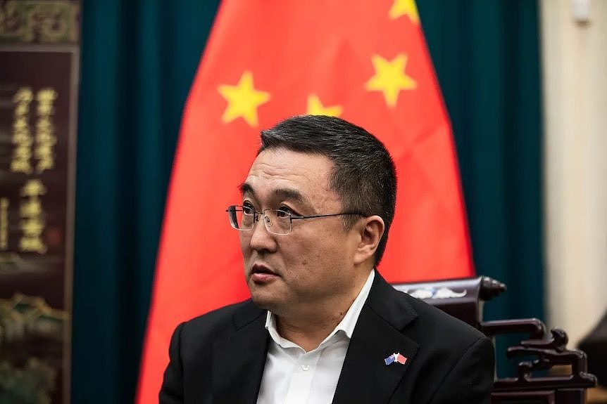 A man in front of Chinese flag. 