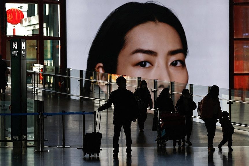 Travellers walk with luggages at a terminal hall