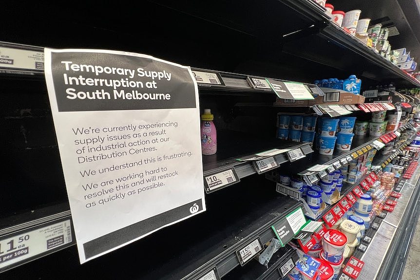 A sign on a supermarket shelf.