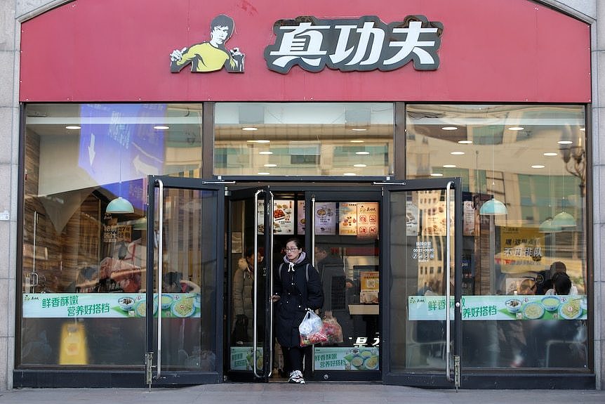 一名女性走出中国连锁快餐店“真功夫”。