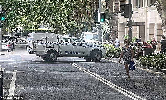 Macleay Street in Potts Point and the area surrounding the Commonwealth Bank branch was cordoned off by police on Friday morning. A police vehicle is pictured at the scene