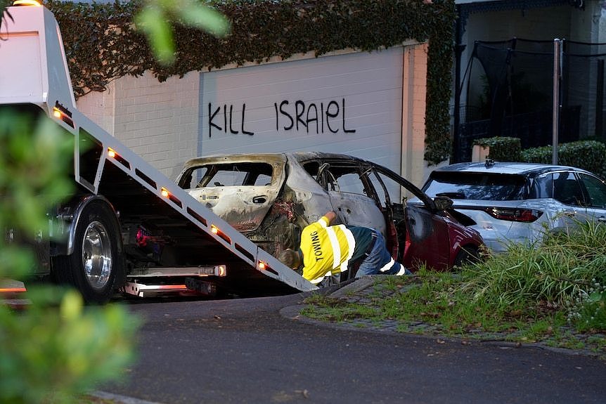 Tow truck and police at garage with graffiti