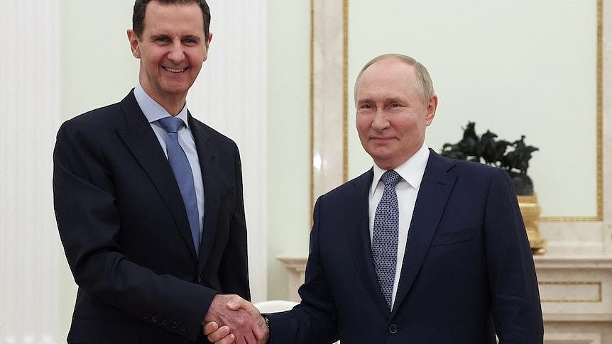 President Bashar al-Assad and President Vladimir Putin shaking hands inside a Kremlin meeting room.