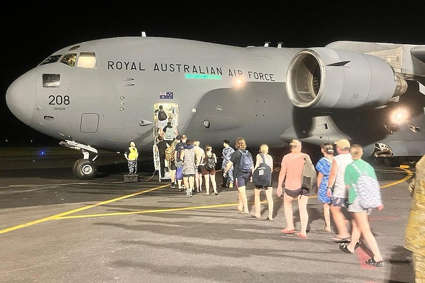 People line up to board a royal australian air force plane in vanuatu