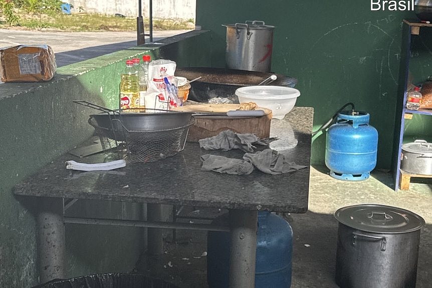 A pan and bread on a table outdoors. 