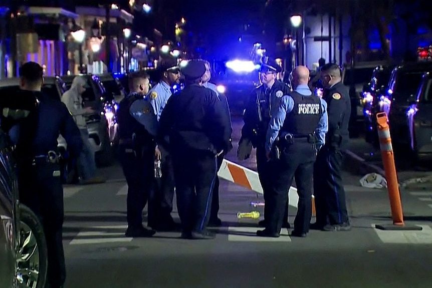 A group of police officers standing on a city street at night