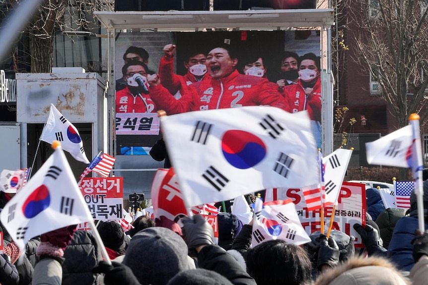 protestors hold south korean flags supporting president yoon