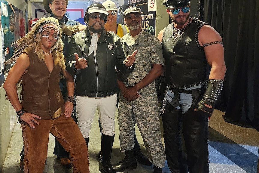 Members of The Village People gathered together backstage while in costume