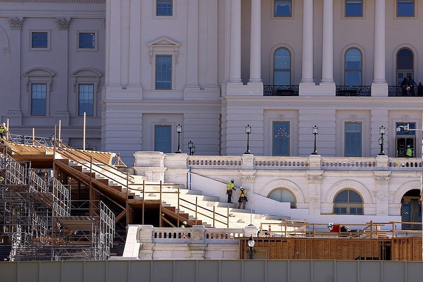 Construction workers build a platform in front of the U.S. Capitol building 