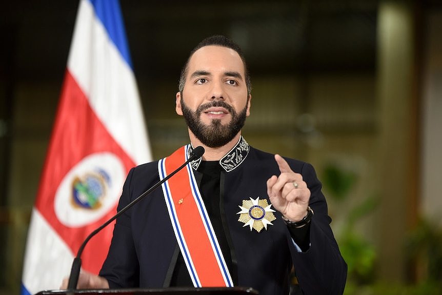 Nayib Bukele speaking at a lectern with a Costa Rican flag behind him