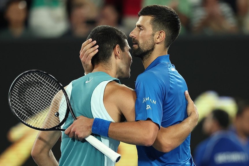 Novak Djokovic shares a hug with Carlos Alcaraz