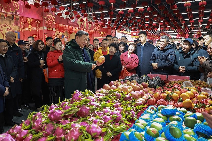 Xi Jinping talks to residents at a food market. 