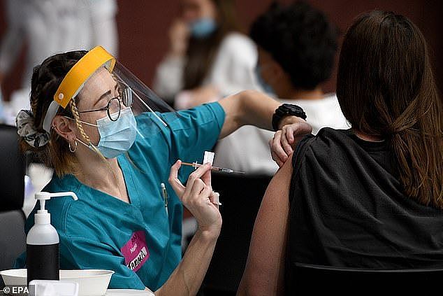 A man who participated in trials for the development of a Covid vaccine now produces false positive HIV test results. Stock image of a woman receiving a vaccine