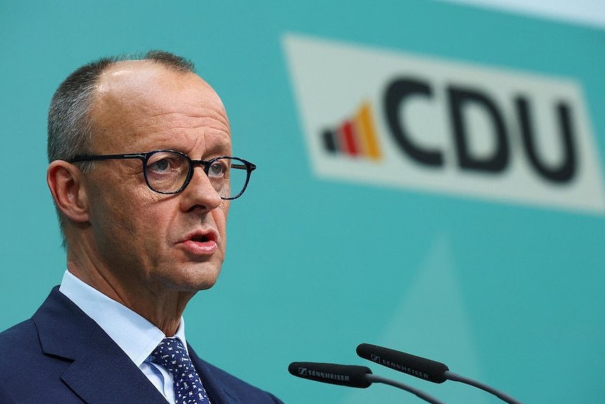 Friedrich Merz at an indoors press conference with the CDU political party logo over his shoulder.