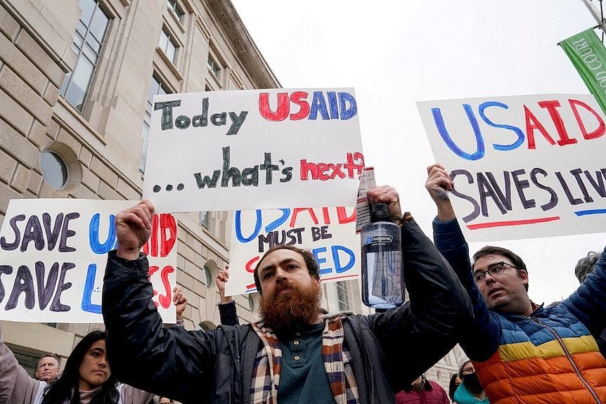 several people holding signs in support of USAID