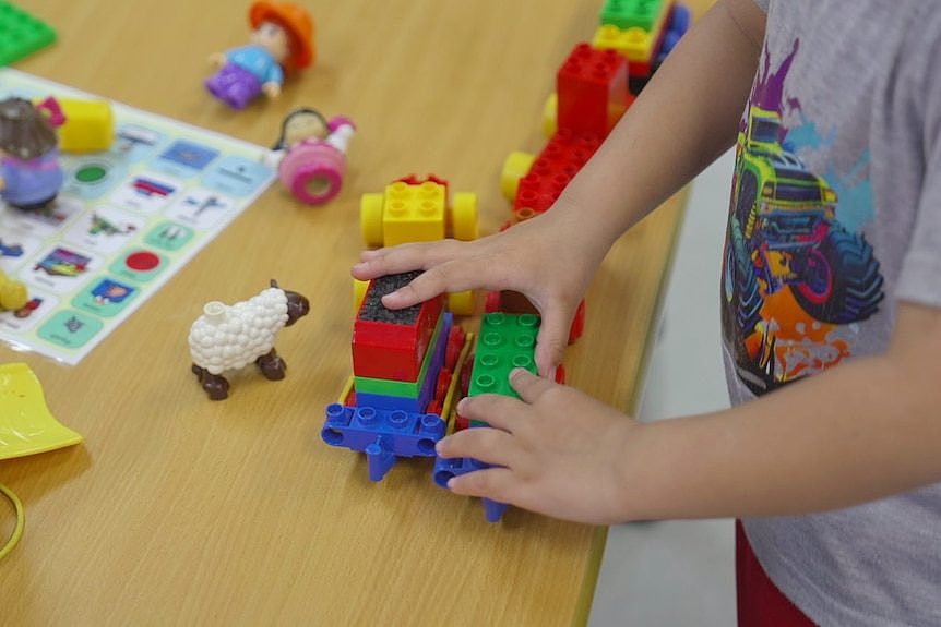 A non-identifiable child playing with toys.