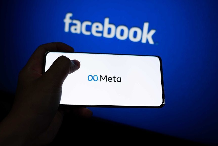 smart phone with meta logo on it in front of blue background with facebook logo