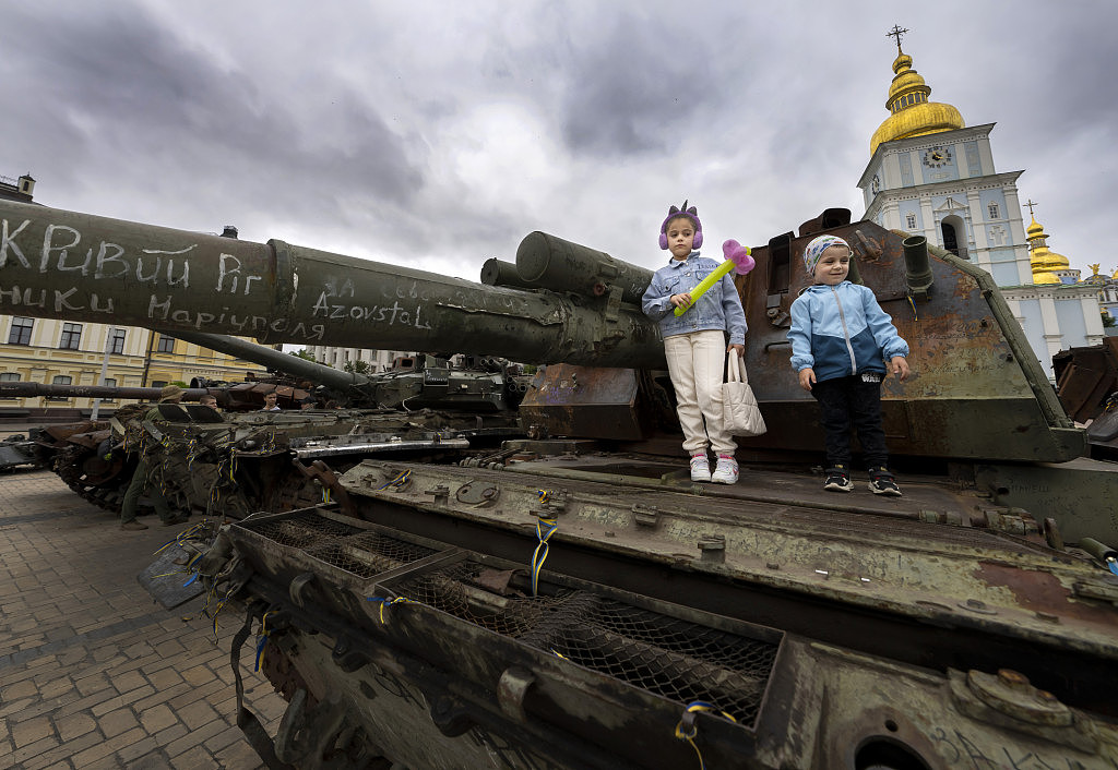孩子們站在烏克蘭基輔聖邁克爾廣場燒毀的俄羅斯坦克上。路透