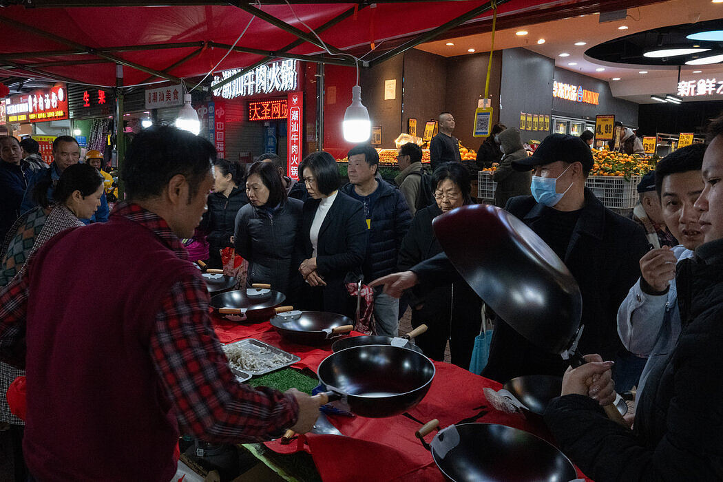 一个售卖炒菜锅的摊位。深圳商场里挤满了香港人，当地人戏称游客“占领”了商场。
