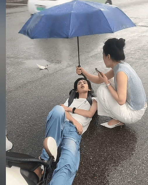 安徽热心女给被撞倒男孩撑伞，网友却被男孩颜值惊呆！网友：帅得出事了还以为在摆拍（视频/组图） - 1