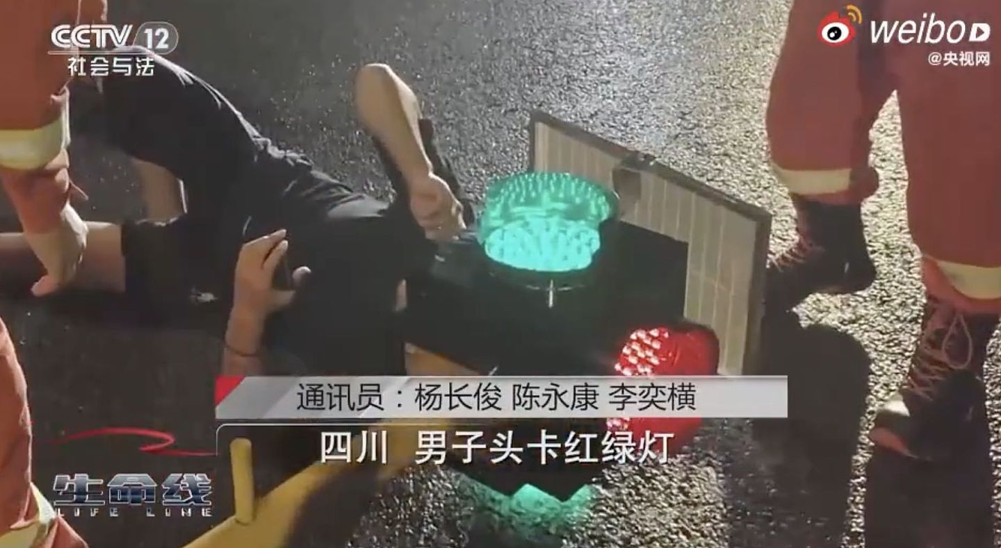 中国男子骑车滑手机！头卡红绿灯箱里，动用切割器才把头拔出来（视频/组图） - 1