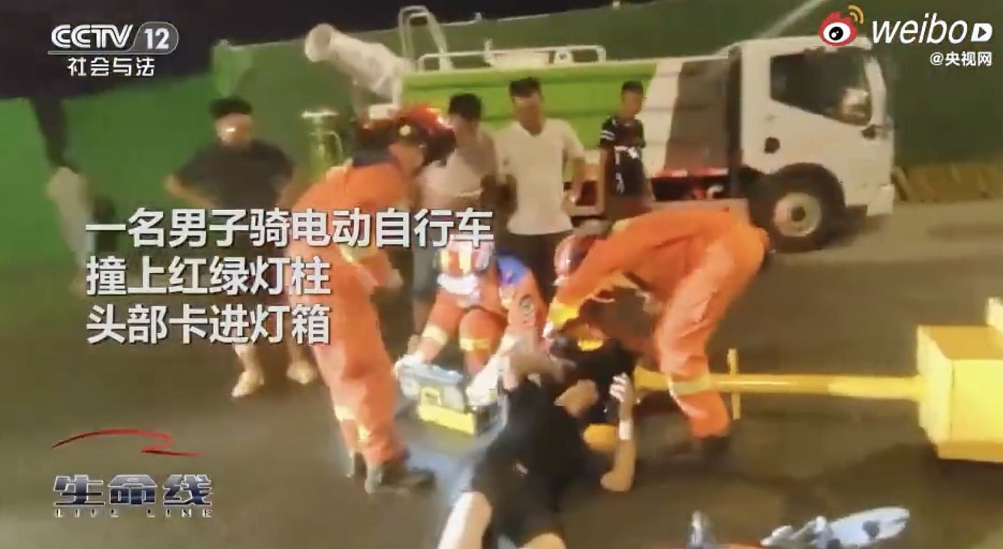 中国男子骑车滑手机！头卡红绿灯箱里，动用切割器才把头拔出来（视频/组图） - 2