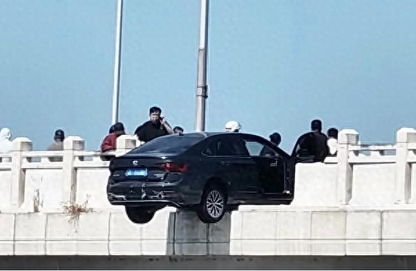 轿车撞断大桥护栏悬空中，过路男子冲上前压住车头（组图） - 1