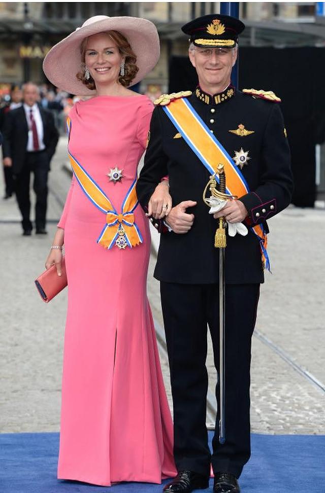 比利时王后真时髦！穿斗篷裙还配同色口罩，走路带风老公甘当陪衬