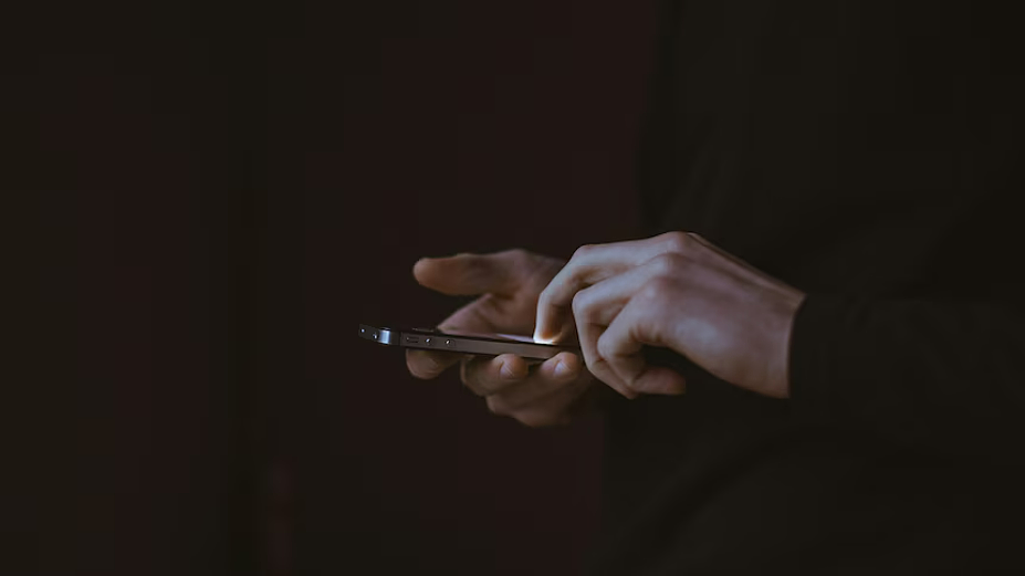 使用手机的手部；原报道资料图，非受害者照片